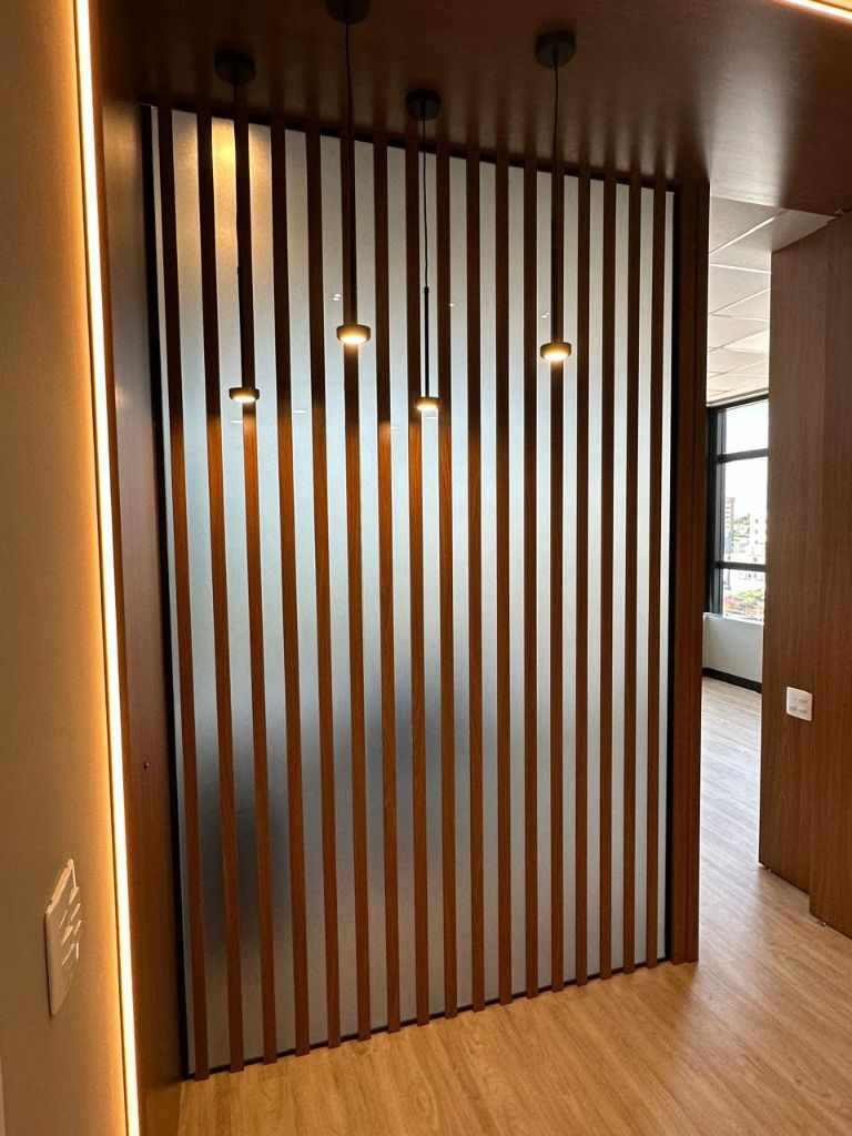 Corredor com ripas de madeira e luminárias pendentes